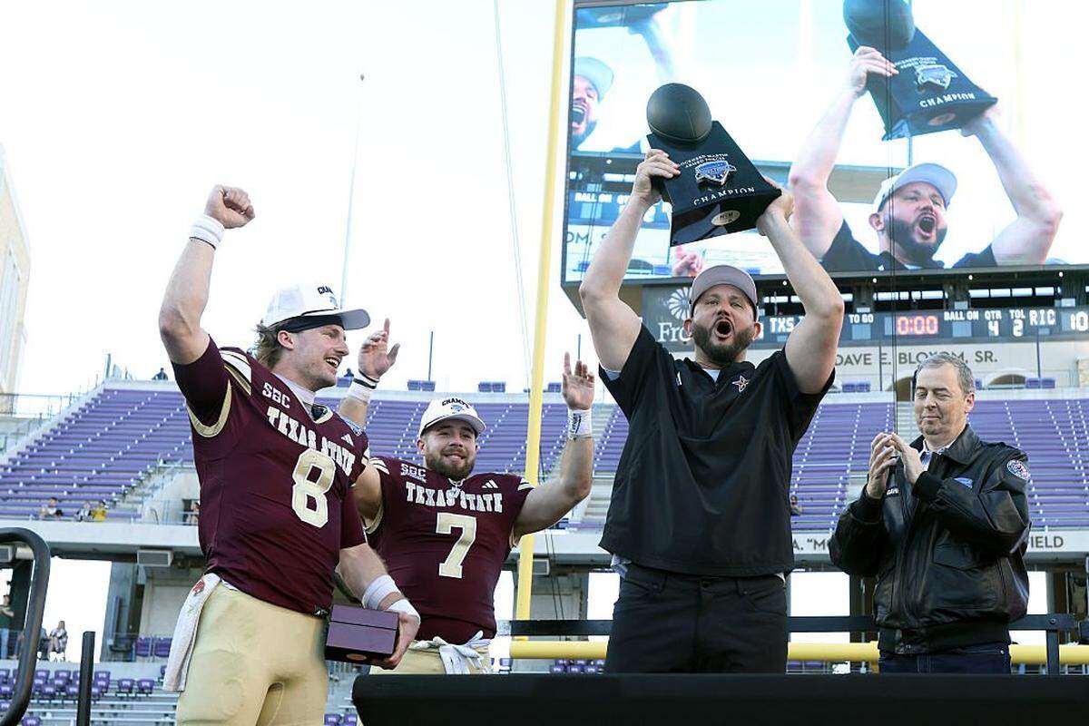 FORT WORTH, TEXAS - JANUARY 02: Head coach GJ Kinne of the Texas State Bobcats holds up the trophy after winning the game against the Rice Owls in the 2026 Lockheed Martin Armed Forces Bowl at Amon G. Carter Stadium on January 02, 2026 in Fort Worth, Texas. (Photo by Tim Heitman/Getty Images)