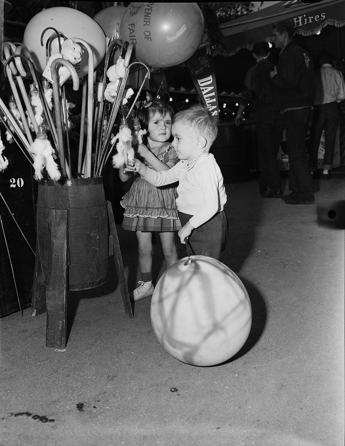 Oct. 24, 1953: Visitors during Fort Worth Day at the State Fair of Texas in Dallas. Among the 100 school students participating in the state baton twirling contest were four from Tarrant County. Children of Mr. and Mrs. Robert B. Leathers of 5121 Kessler, are pictured here. Left to right, Barnett Sykes Leathers, 2, and his sister, Margaret Jo, 3, were not participants.