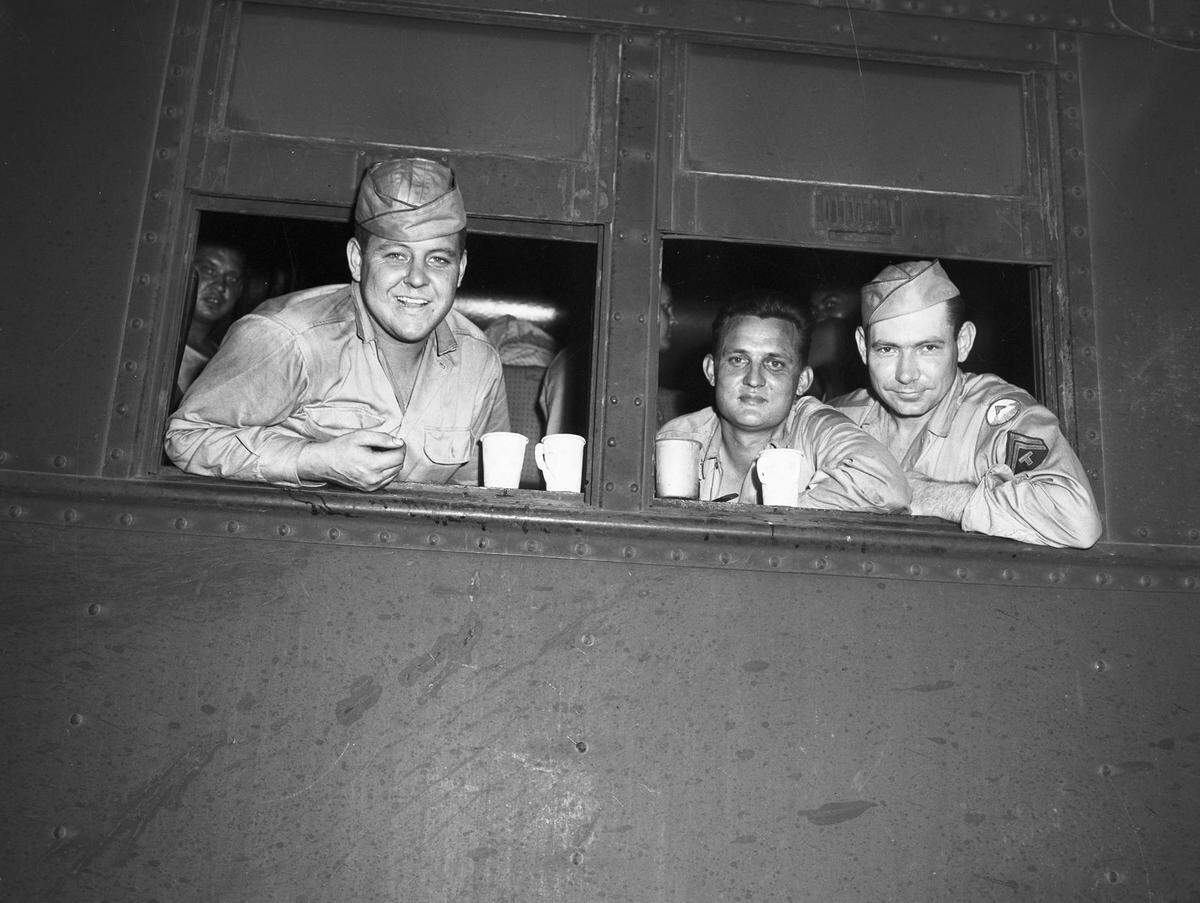 Three soldiers peer out of a train car in Fort Worth June 25, 1945, on their way to Fort Sam Houston in San Antonio. From left to right: Corporal Ted Schinwolf, Private First Class Willie Harmon and Private First Class Robert L. Comte.
