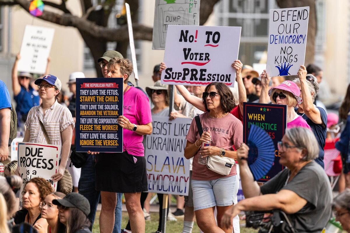 Rally attendees holds signs and rally during the ‘Good Trouble’ rally in Burk Burnett Park in downtown Fort Worth on Thursday, July 17, 2025.