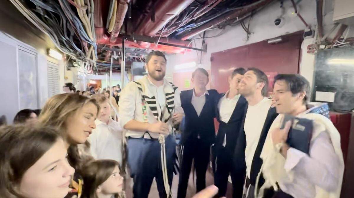 Ira Savetsky (far right) leads worship services while Lizzy Savetsky and daughters Stella and Juliet (lower left) join in prayer in a bomb shelter at King David Hotel:
