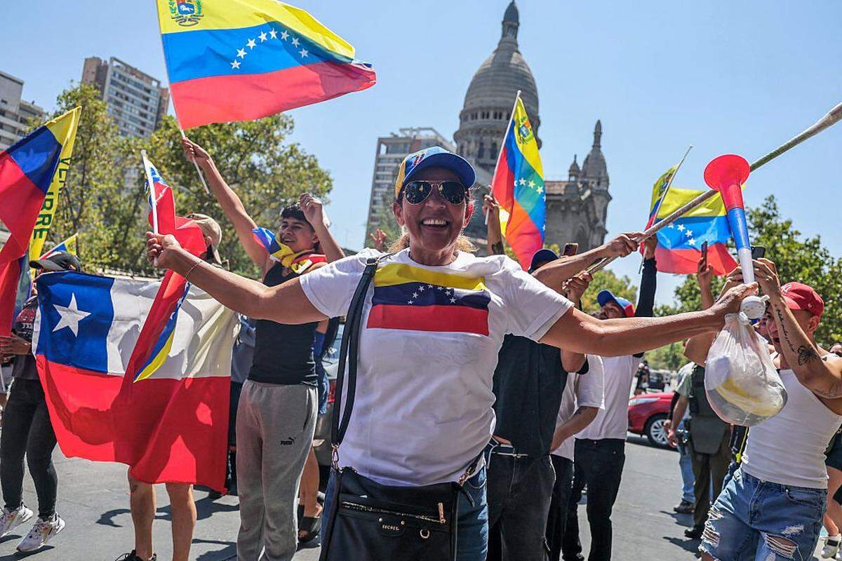 Venezuelans living in Chile celebrate in Santiago on January 3, 2026, after US forces captured Venezuelan leader Nicolas Maduro. President Donald Trump said Saturday that US forces had captured Venezuela's leader Nicolas Maduro after bombing the capital Caracas and other cities in a dramatic climax to a months-long standoff between Trump and his Venezuelan arch-foe. (Photo by Javier TORRES / AFP via Getty Images)