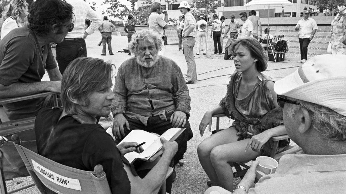 Cast and crew members of the movie “Logan’s Run” take a break on the Fort Worth Water Garden set in 1975. From left are director Michael Anderson, Michael York, Peter Ustinov, Jenny Agutter, and producer Saul Davis. Production personnel wait in the background.