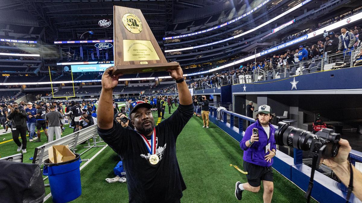 North Crowley Head Coach Ray Gates hoists the championship trophy after winning the UIL 6A Division I state championship game against Austin Westlake at AT&T Stadium in Arlington on Saturday, Dec. 21, 2024.