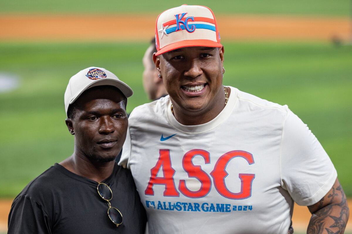 Kansas City Royals catcher Salvador Perez takes a photo with Dennis Kasumba, a 20-year old Ugandan baseball player who has gone viral multiple times for his training videos, on the field prior to the 2024 MLB All Star Game at Globe Life Field in Arlington on Tuesday, July 16, 2024. Perez not only made the effort to meet Kasumba, but also gave him his All Star Game catchers gear.