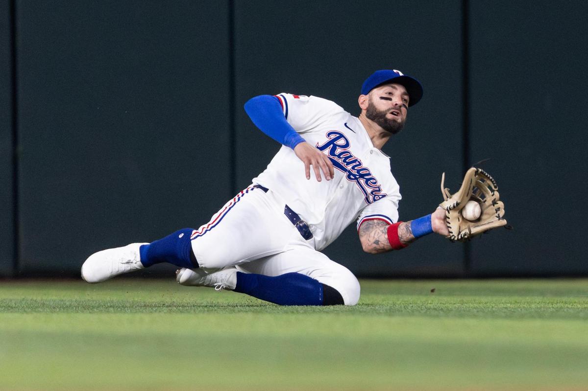 Rangers center fielder Kevin Pillar (1) makes a sliding catch from a ball hit in center field by Red Sox short stop Trevor Story (10) in the seventh inning of the MLB Opening Day game between the Rangers and Red Sox at Globe Life Field in Arlington on Thursday, March 27, 2025.