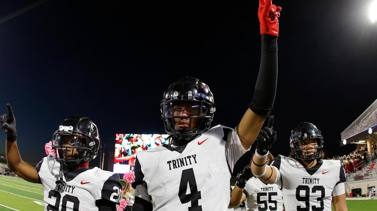 Trinity running back Josh Bell (20), wide receiver Jarvis Heimuli (4) and defensive lineman Michael Tilmon (93) acknowledge the school song before the first half of a UIL high school football game at Crowley ISD Multi-Purpose Stadium in Crowley, Texas, Friday, Oct. 20, 2023.