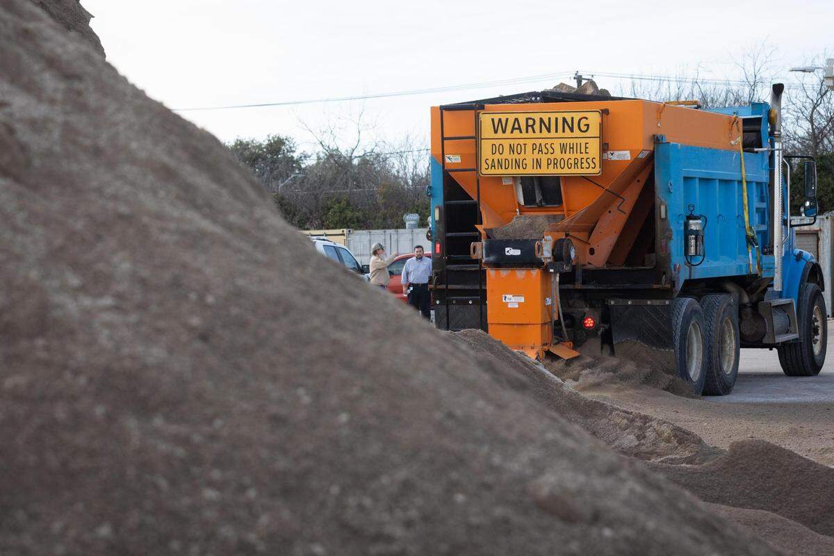 A pile of sand and and salt mixture sits ready as a truck demonstrates how the mixture is distributed onto the roads as the city prepares for a winter storm Monday, Jan. 31, 2022, in Fort Worth.