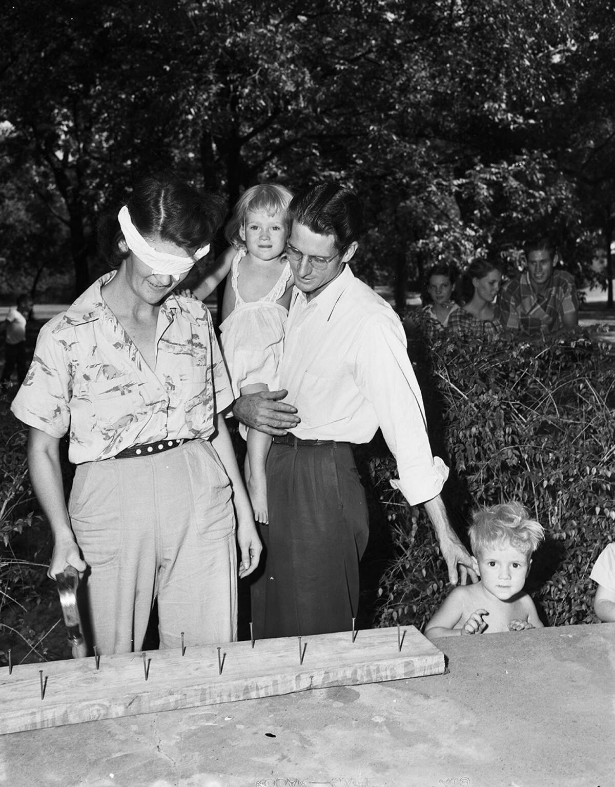 Sept. 4, 1951: Hammering while blind folded in a Labor Day contest at Sycamore Park proved more fun than trouble for Mrs. Harvey Cato. Her husband, a sheet metal worker, looked on while holding their 3-year-old child, Gale Lynn Cato.