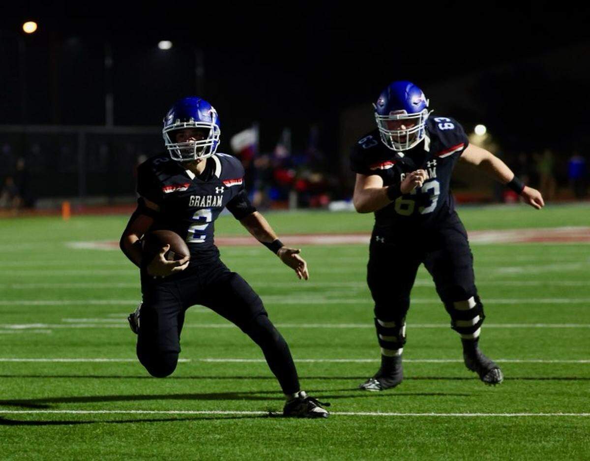 Graham running back Rylan Monsey (2) hits the hole provided by offensive lineman Colter Johnson (63) against Brock on Friday, Nov. 1, 2024 at Newton Field in Graham, Texas.