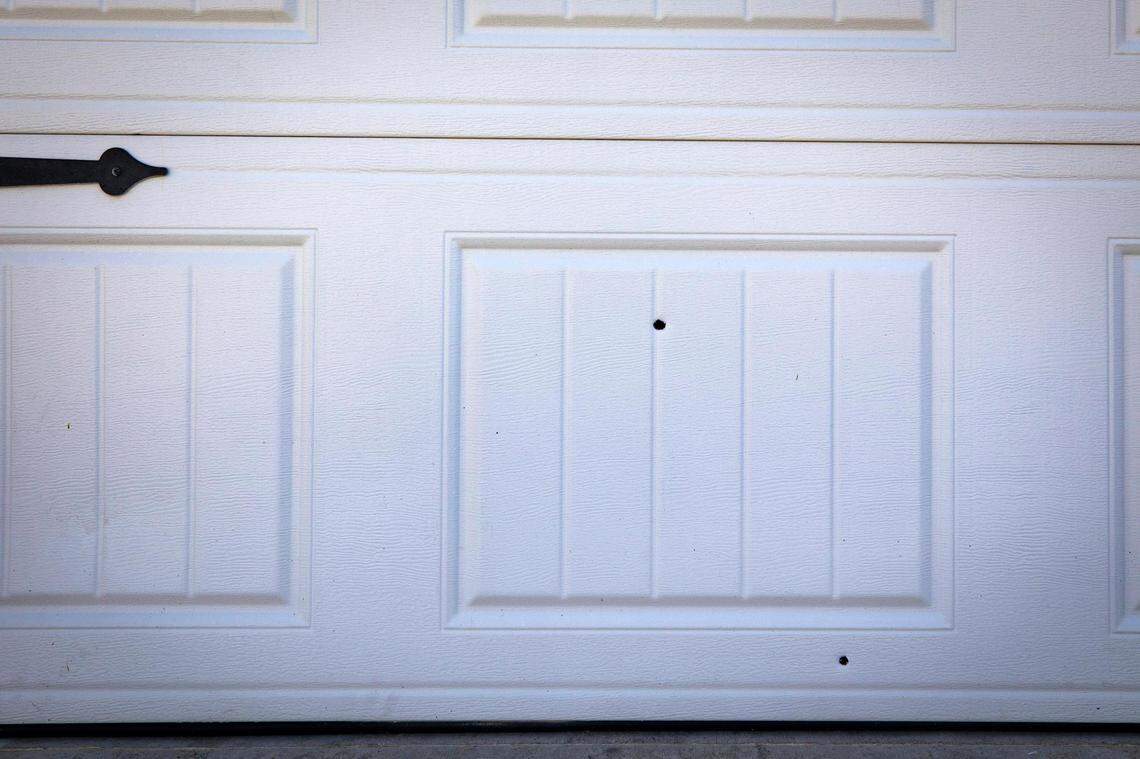Bullet holes are visible in the garage door at the Fort Worth home where 5-year-old Rayshard Scott and 17-year-old Jamarrien Monroe were fatally shot in 2022. A toddler was also injured in the shooting.