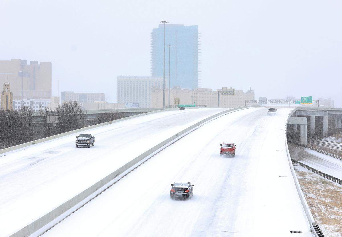 Vehicles drive on a snowy Interstate 30 in Fort Worth on Thursday, February 3, 2022.