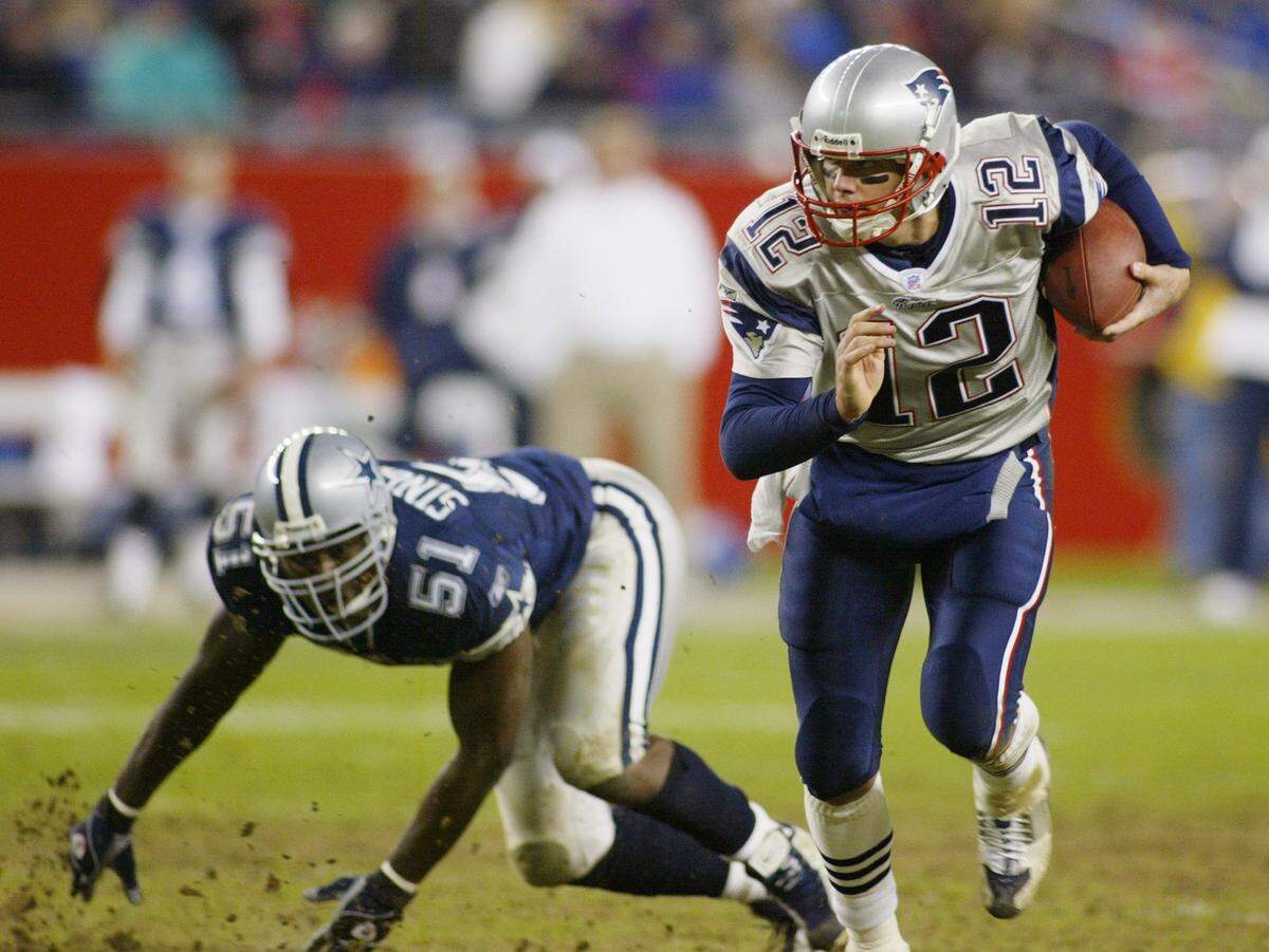 New England quarterback Tom Brady scrambles around Cowboys Al Singleton, in the fourth quater against the Dallas Cowboys at Gillete Stadium in Foxborough, Mass., on Oct. 16, 2003.