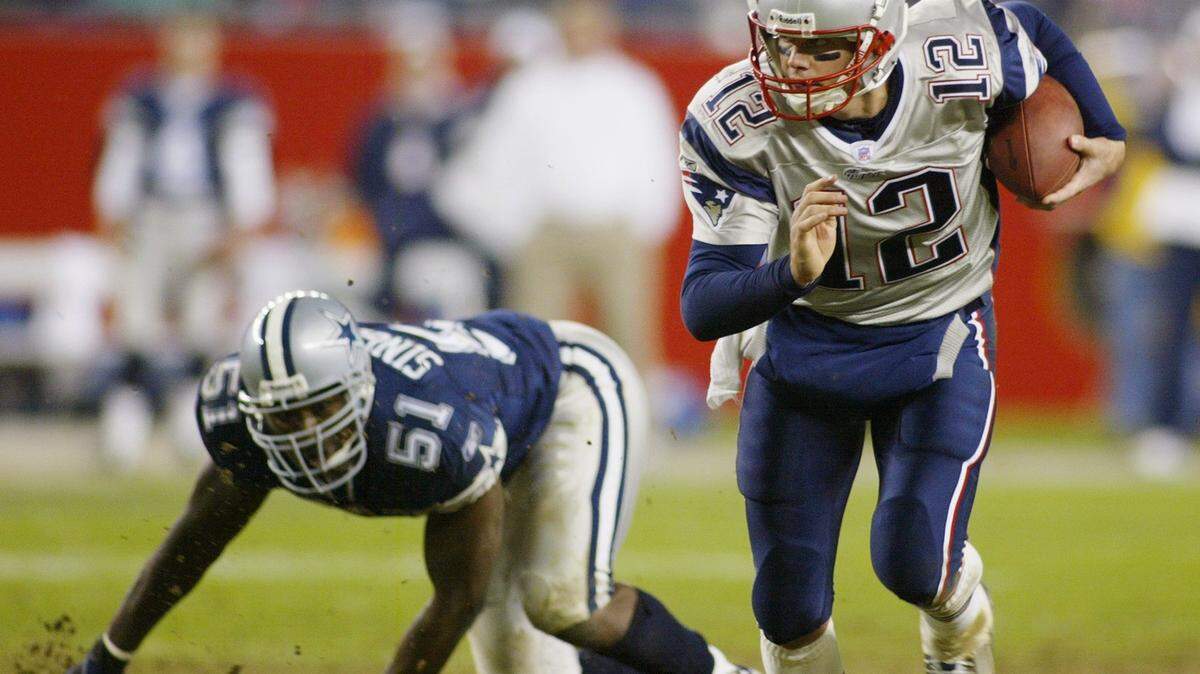 New England quarterback Tom Brady scrambles around Cowboys Al Singleton, in the fourth quater against the Dallas Cowboys at Gillete Stadium in Foxborough, Mass., on Oct. 16, 2003.