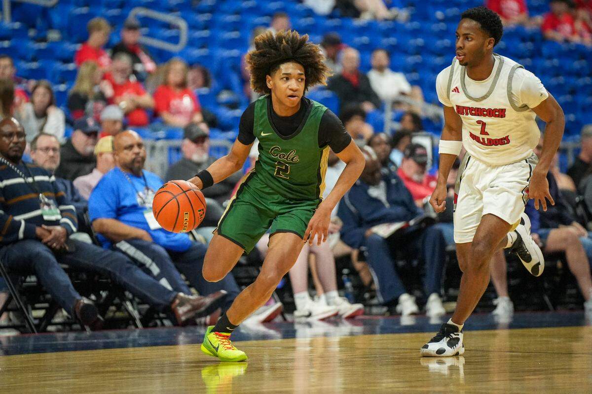 San Antonio Cole guard James Livingston (2 in green) drives around Hitchcock’s Damien McDaniel (2 in white) in a Class 3A state semifinal on Thursday, March 7, 2024 at the Alamodome in San Antonio, Texas. Hitchcock defeated Cole 57-40.