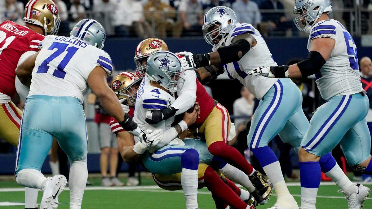 Dallas Cowboys quarterback Dak Prescott is sacked by San Francisco 49ers defensive end Nick Bosa, center left rear, during the first half of Sunday’s playoff game in Arlington.