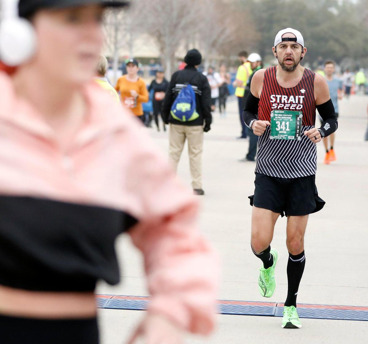 Dustin Darakhshan crosses the ultra marathon finish line for third with a time of 3:17.11 during the 2023 Cowtown Marathon in Fort Worth, Texas, Sunday, Feb. 26, 2023. Almost 21,000 runners registered for the two day event. (Special to the Star-Telegram Bob Booth)