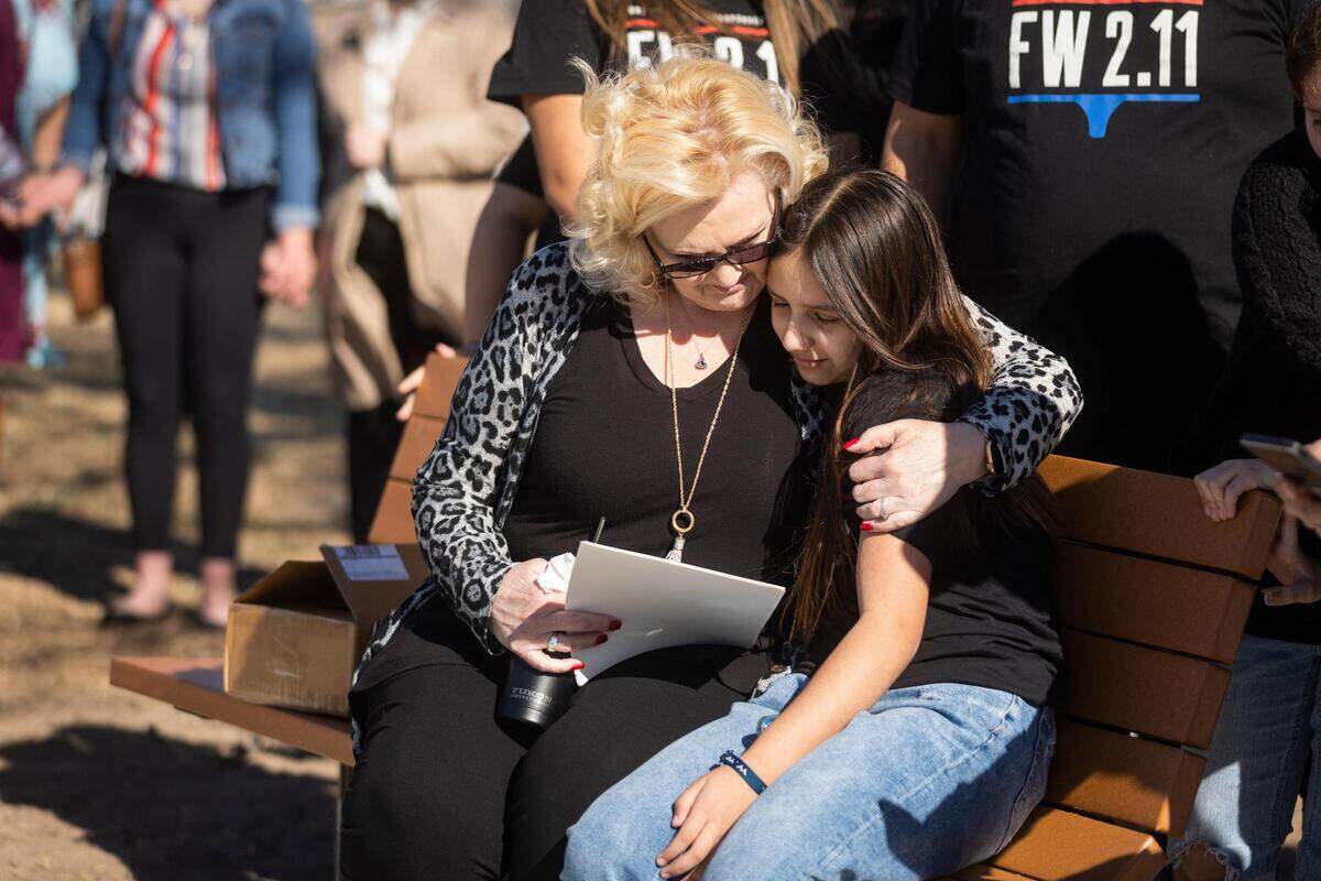 Cindy Gerred holds Emri Contreras, the daughter of Tiffany Gerred, while sitting on new benches dedicated as a memorial for the victims of the I-35W pileup crash Friday, Feb. 11, 2022, at Riverside Park in Fort Worth.
