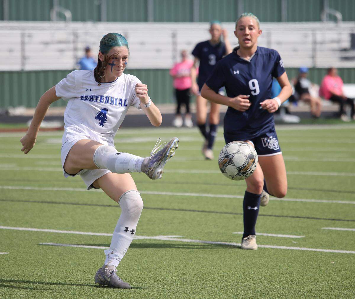 Burleson Centennial defender Avery Slattery (4) kicks the ball cross the pitch away from Prosper Walnut Grove midfielder Brynlie Ward (9) during the first half of a UIL Conference 5A Division I state semifinal soccer game at Keller ISD Athletic Complex in Keller, Tx. Friday, April 03, 2026.