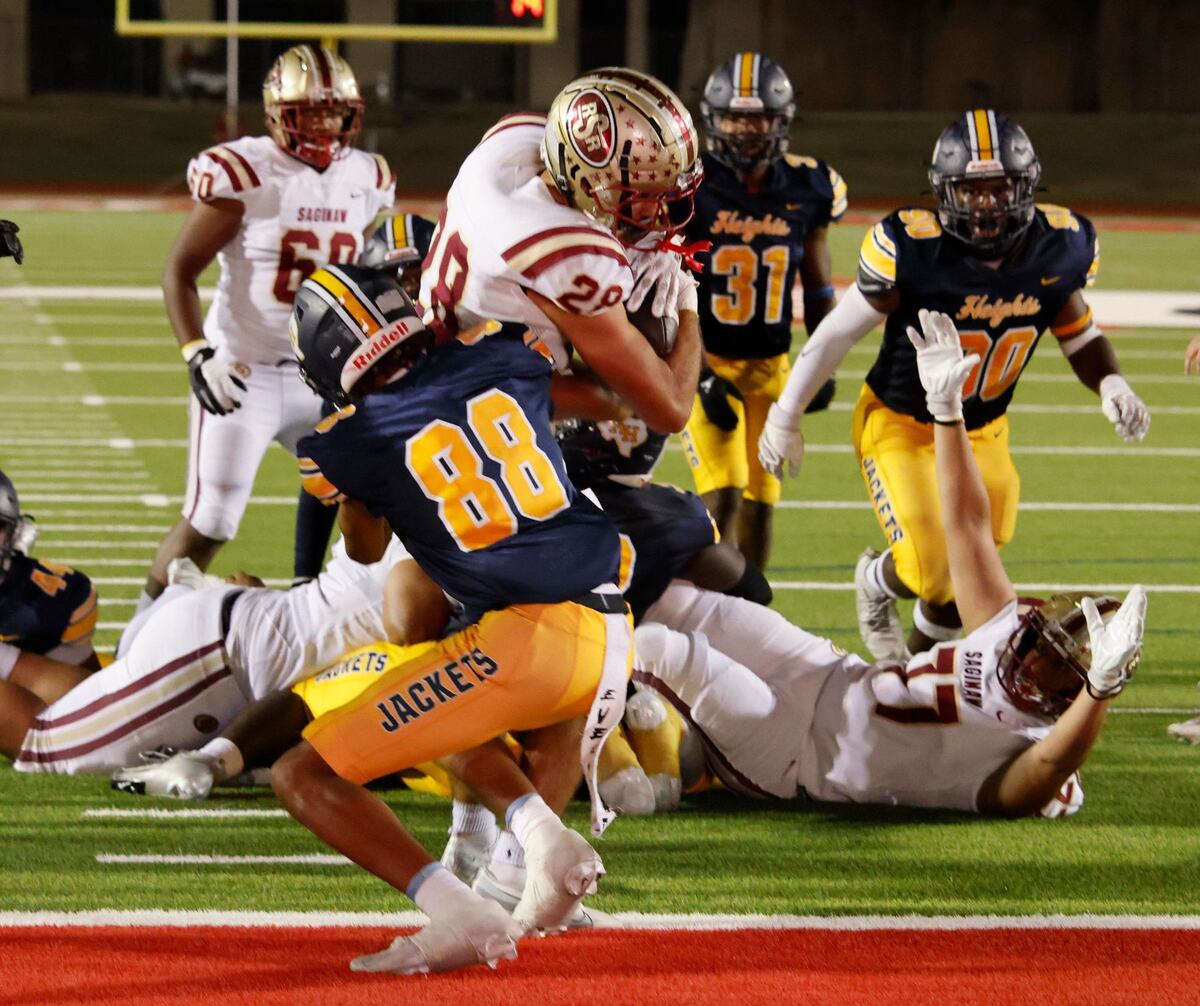 Saginaw running back Isaiah Quinones (28) scores the go ahead on a three yard run defended by Arlington Heights defensive back Antonio Johnson (88) during a District 4-5A D1 football game at Farrington Field in Fort Worth, Texas, Thursday, Oct. 10, 2024. (Special to the Star-Telegram / Bob Booth)