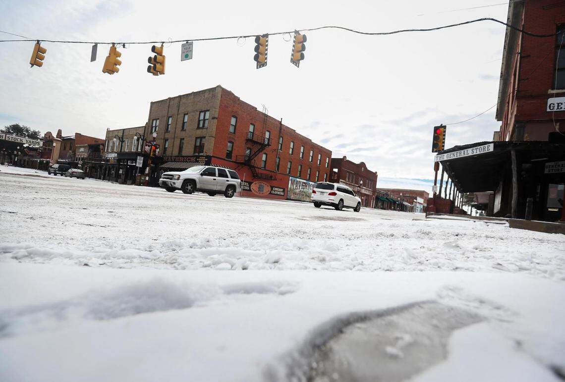 Vehicles slowly make their way through the intersection of North Main Street and Exchange Avenue on Feb. 16, 2021, in Fort Worth.