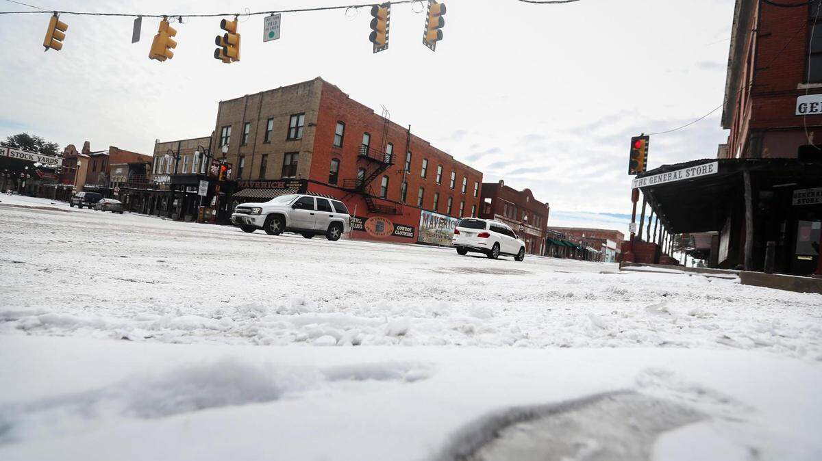 Vehicles slowly make their way through the intersection of North Main Street and Exchange Avenue. A winter storm was expected to move into the DFW area Tuesday evening, bringing more ice and snow.