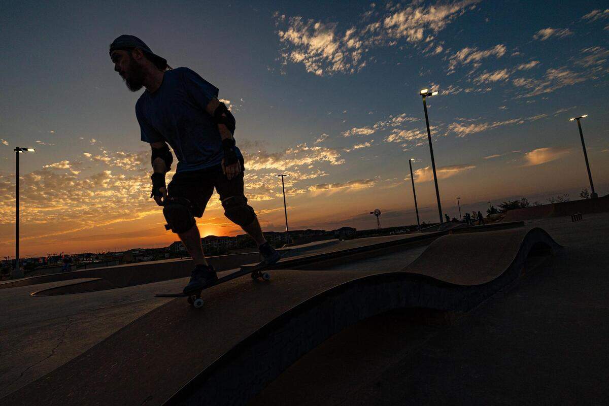 A skater skates down a slope at sunset at Chisholm Trail Skate Park in Fort Worth on Tuesday, Aug. 29, 2023.
