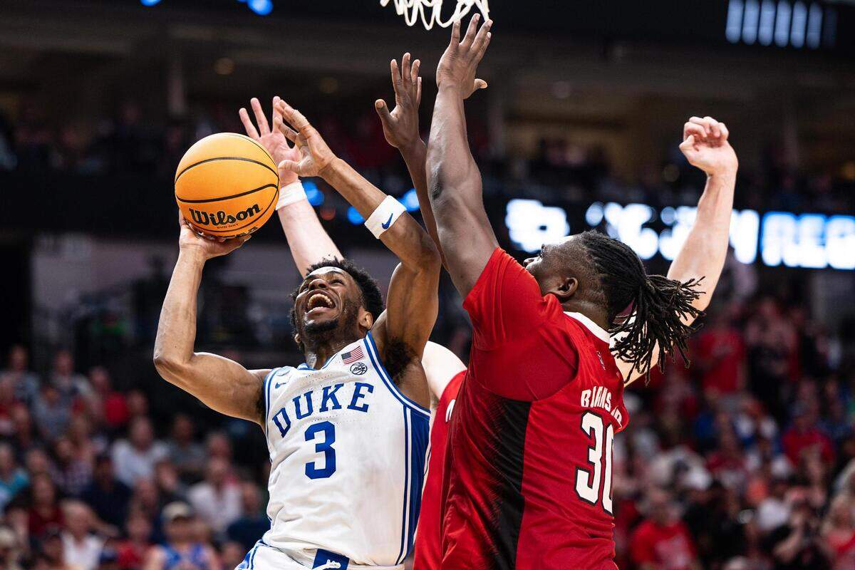 Duke guard Jeremy Roach (3) goes up for a layup against NC State forward DJ Burns Jr. (30) in the second half of the Elite 8 South Regional Championship game between the Duke Blue Devils and NC State Wolfpack of NCAA Division I Mens Basketball Tournament at American Airlines Center in Dallas on Sunday, March 31, 2024. NC State defeated Duke 76-64.