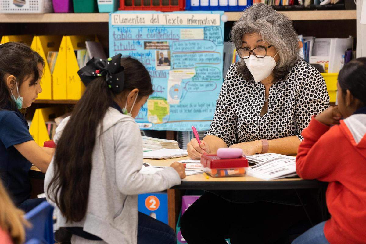 Second grade teacher Eliza Rodriguez works with students during a bilingual class at M. H. Moore Elementary in Fort Worth.