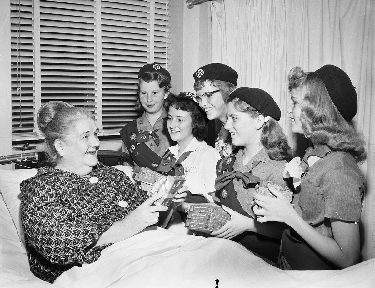 Dec. 5, 1958: Mrs. Jean Anderson was one of the patients in the women’s surgical ward of Peter Smith Hospital who received Christmas gifts from members of Girl Scout Troop 284. The young givers are Elsa Fay Hall, Rebecca Walley, Sally Remeur, Kathleen Crawford and Mary Sharp, left to right. The troop also plans a Christmas party for ward patients.