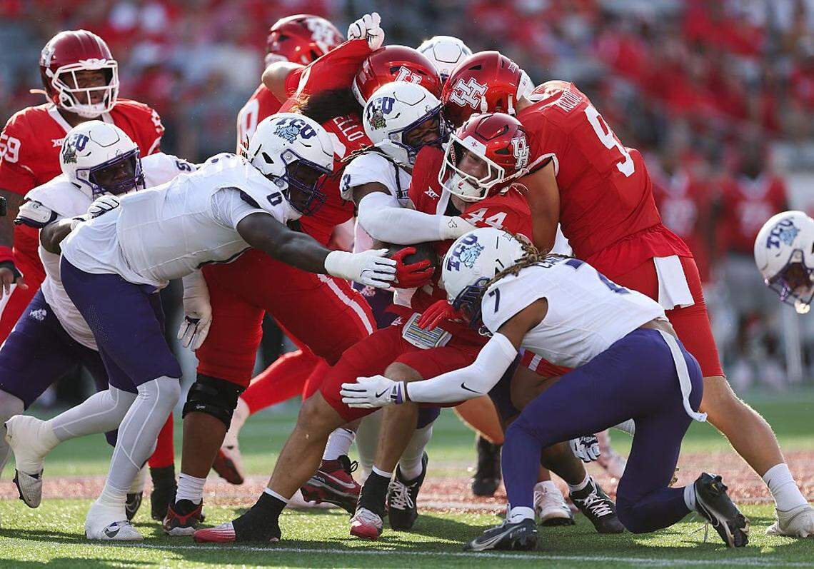 HOUSTON, TEXAS - NOVEMBER 22: Dean Connors #44 of the Houston Cougars is tackled by Channing Canada #7, Kaleb Elarms-Orr #3, and Zachary Chapman #0 of the Texas Christian University Horned Frogs in the first quarter of the game at TDECU Stadium on November 22, 2025 in Houston, Texas. (Photo by Kenneth Richmond/Getty Images)