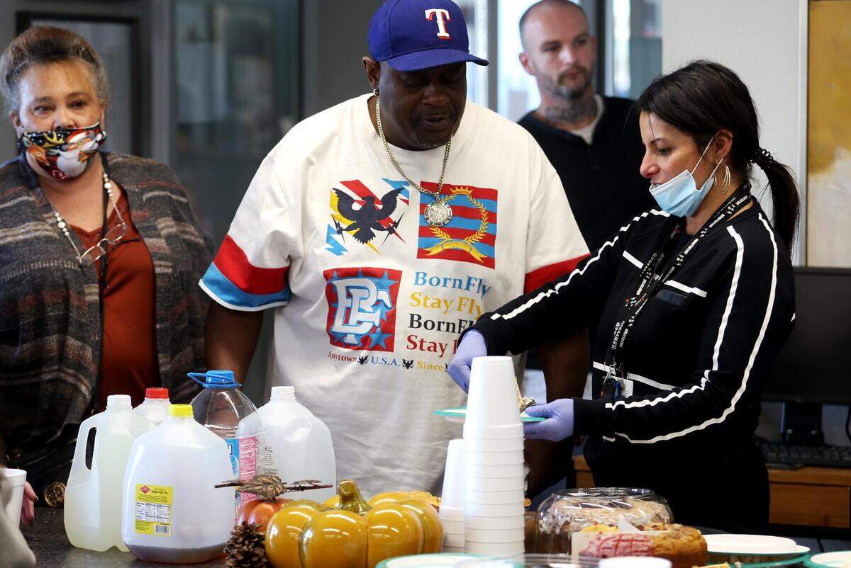 Connie Pena, a MHMR of Tarrant County employee who works at Casa de Esperanza, serves residents dessert during a Thanksgiving meal. Community events like these are ways she says the providers give back to the residents.