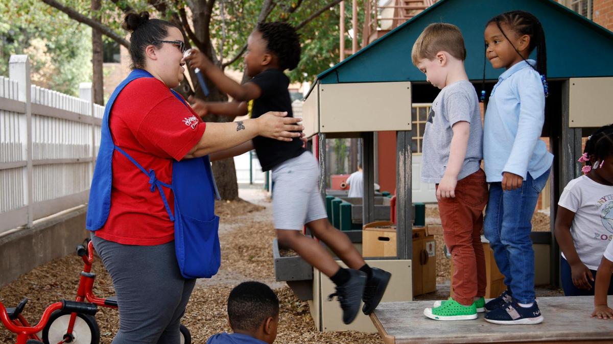 Preschool teacher Leyda Rodriguez catches children as they jump off a very short table at the Rosie K. Mauk Child Development Center in Fort Worth on Sept. 13, 2023.