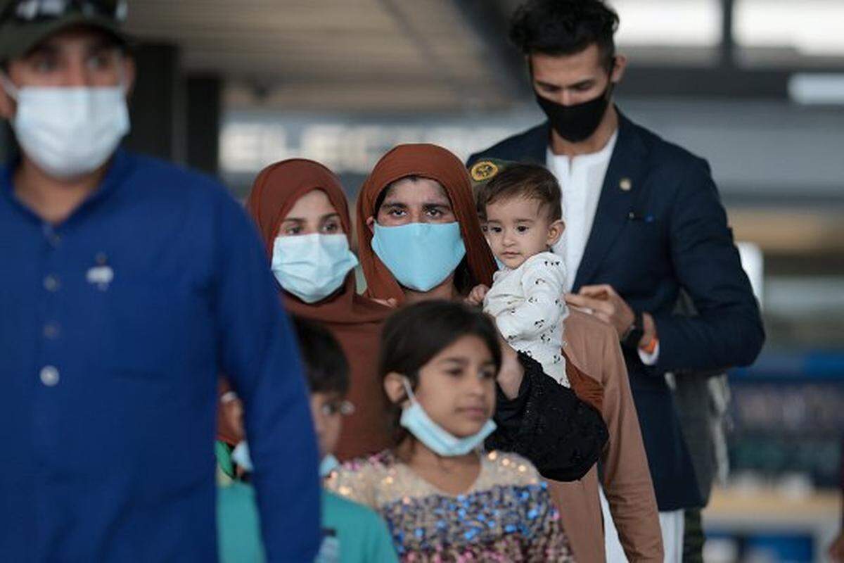 Refugees walk through Dulles International Airport in Virginia on Aug. 31, 2021, after being evacuated from Kabul following the Taliban takeover of Afghanistan.