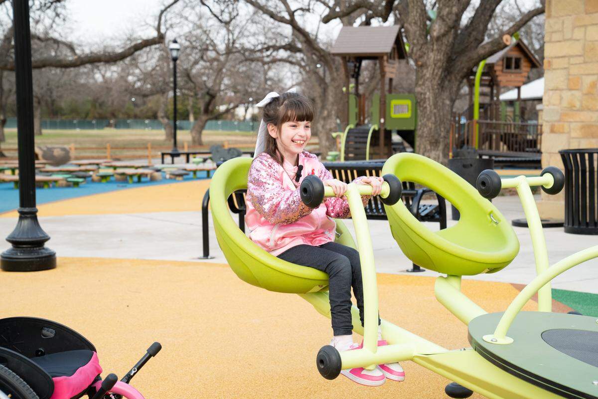 Callie Curtis, age 9, enjoys the new inclusive playground, one of the largest in the state, at Rose Park in Mansfield.