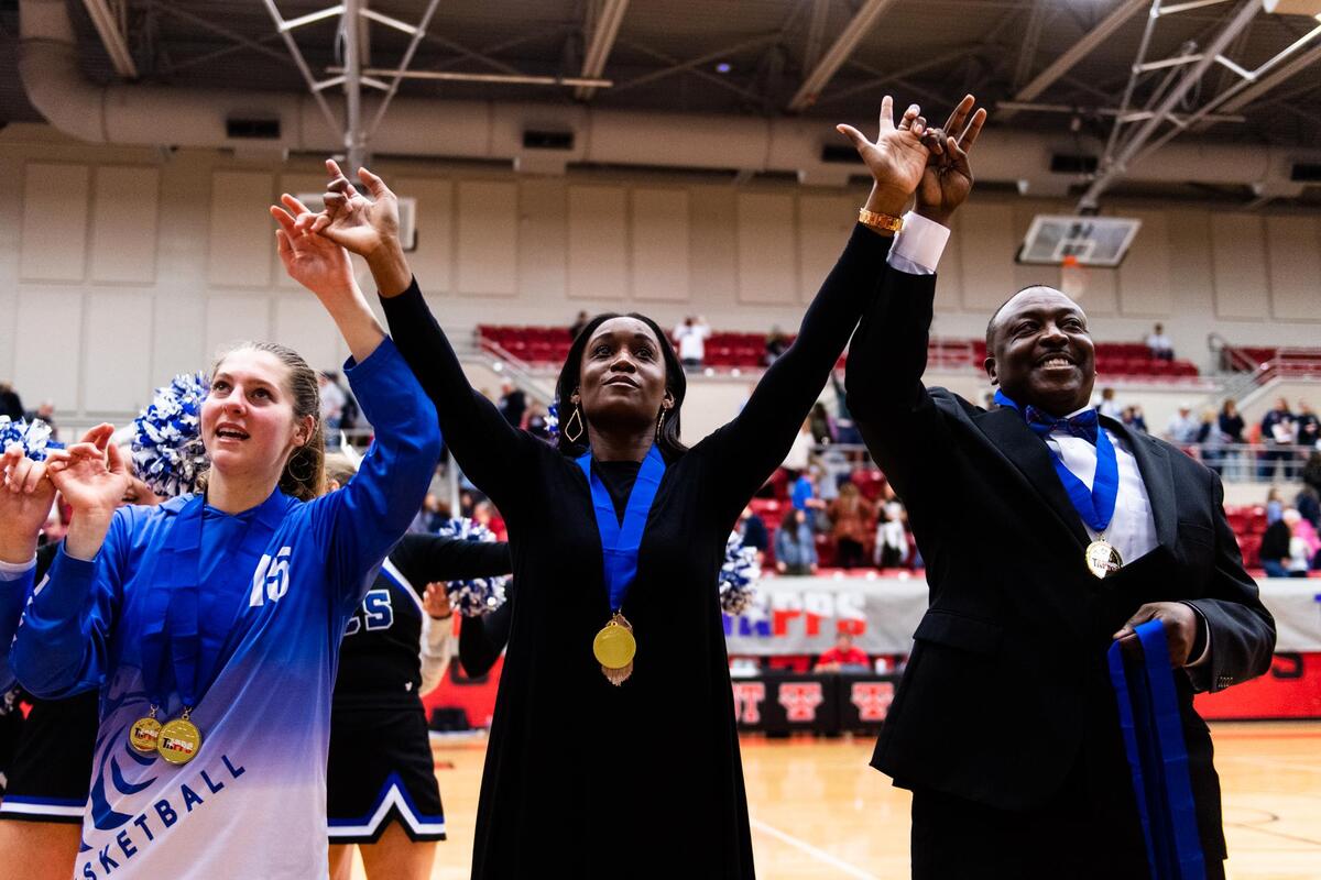 Fort Worth Southwest Christian’s lone senior Jillian Norman, assistant coach Jessika Robinson and head coach Larry Menendez Jr. sing the school’s song after winning the TAPPS 5A girls basketball championship against Second Baptist on Friday in West.
