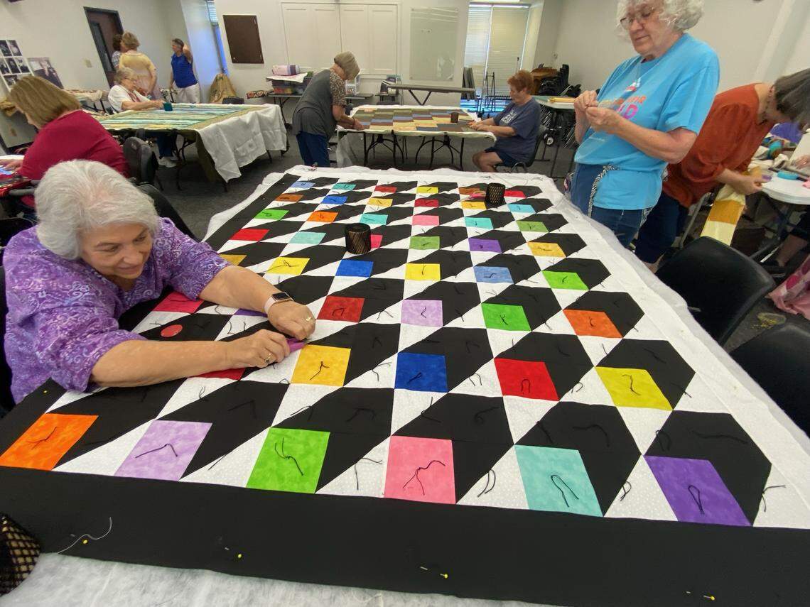 Members of The Hills Quilting Ladies work to complete quilts with leftover material from Verna Mae Brashear.