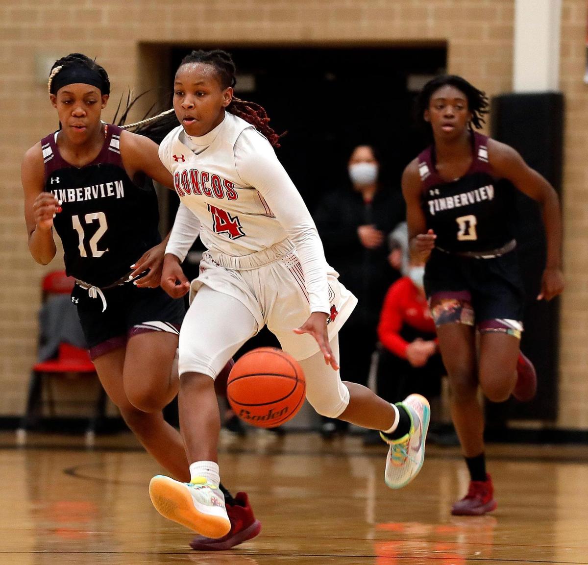 Legacy guard Sirviva Legions (4) drives the ball ahead of Timberview forward Chrishawn Coleman (12) and guard Stephanie Mosley (0) in the first half of a 8-5A district high school girls basketball game at Legacy High School in Mansfield, Texas, Friday, Jan. 22, 2021. The Lady Broncos led the Lady Wolves 22-11 at the half. (Special to the Star-Telegram Bob Booth)