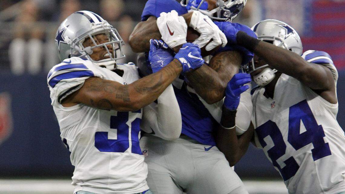 Ex=Dallas Cowboys cornerback Orlando Scandrick (32) and Dallas Cowboys cornerback Morris Claiborne (24) combine to take down New York Giants wide receiver Odell Beckham (13) in second half action as the Dallas Cowboys hosted the New York Giants at AT&T Stadium in Arlington, TX, on Sunday, September 11, 2016.