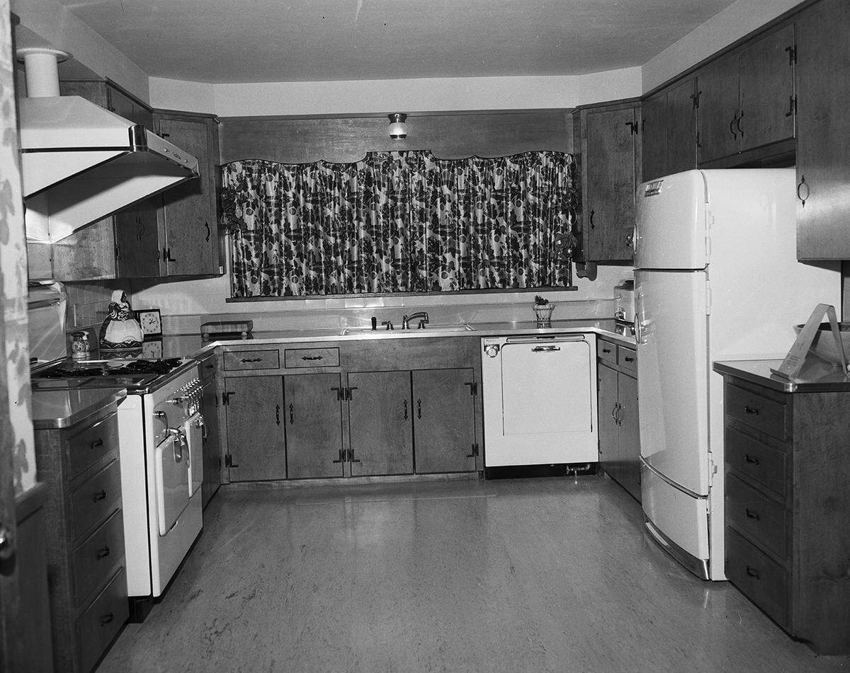 April 21, 1951: Ideal placement of oven, electric dish washer and refrigerator are shown in this large but compact kitchen at the new home of Mr. and Mrs. Pat L. Davis, 4104 Ranier Court. Woodwork is of solid maple in a honey finish. The chintz drapes over the triple window open up a wooded valley scene from the kitchen sink.