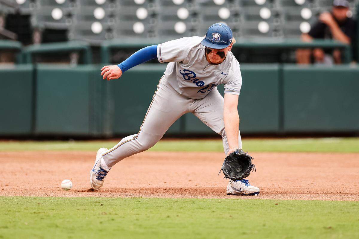 Brock third baseman Asher Strait (20) reaches his glove down toward the ground to field the ball against Robinson in the UIL Class 4A Division II baseball state championship game on Friday, June 5, 2026, at Dell Diamond in Round Rock, Texas.