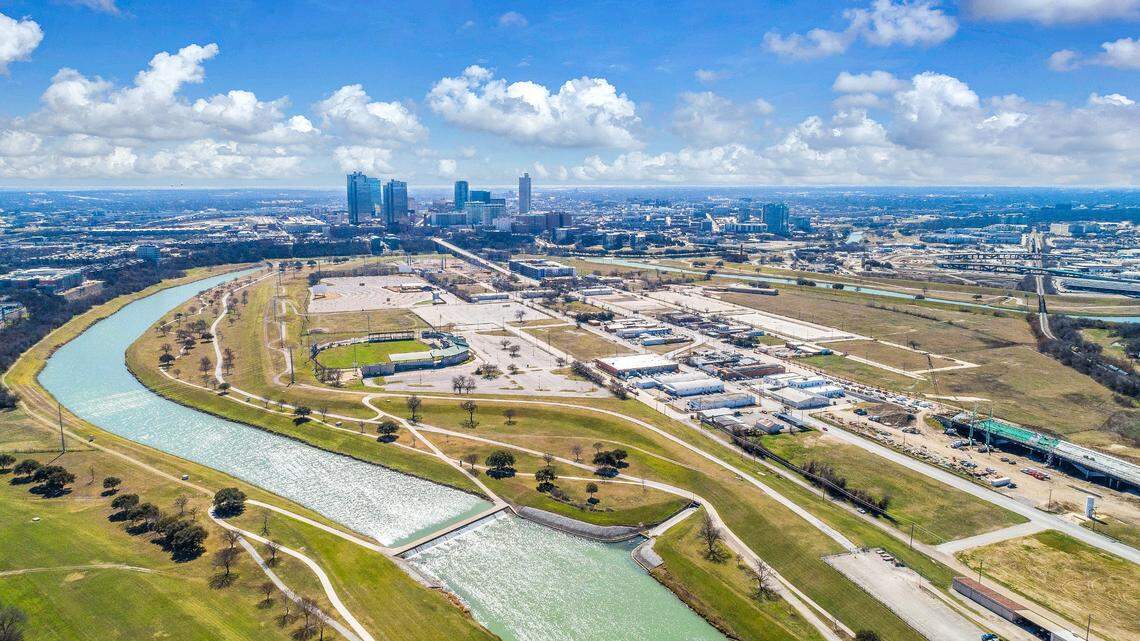 An aerial shot of a man made island with the Fort Worth skyline in the background.