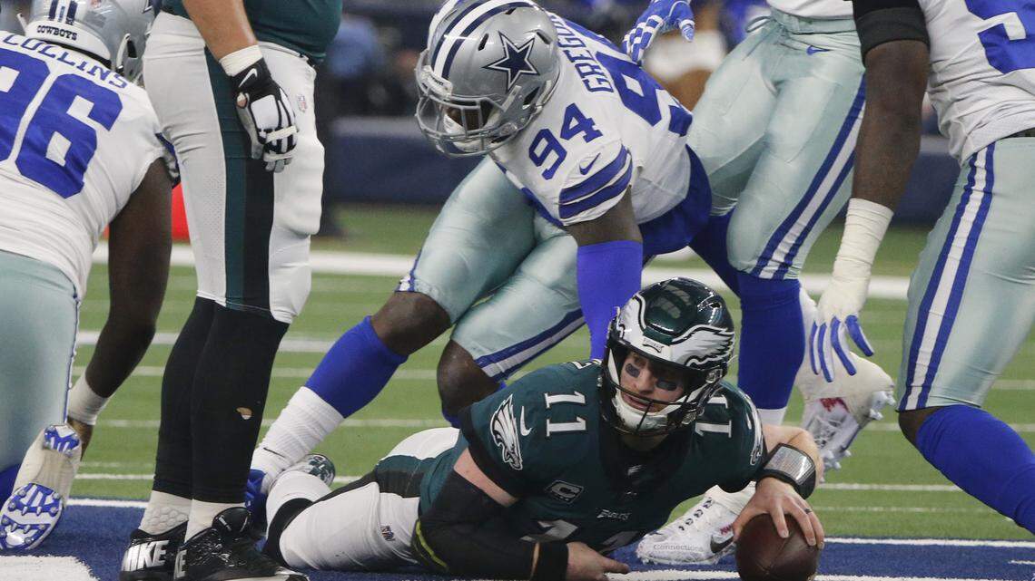 Philadelphia Eagles quarterback Carson Wentz (11) is sacked by Dallas Cowboys defensive end Randy Gregory (94) during the first half of an NFL football game, in Arlington, Texas, Sunday, Dec. 9, 2018. (AP Photo/Michael Ainsworth)