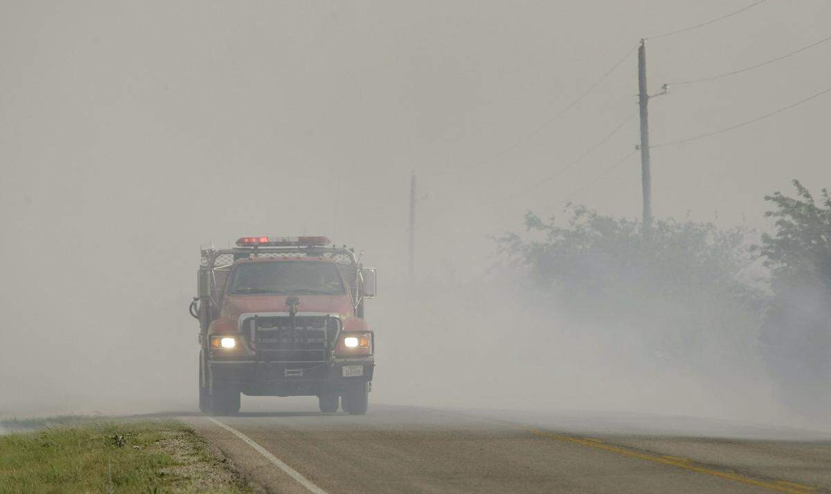 A fire truck passes a spot on 1287 where flames flared up unchecked south of Graham on April 15, 2011.