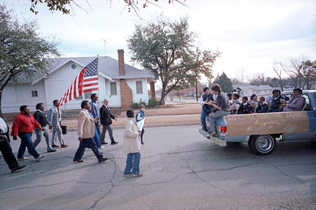 Jan. 15, 1986: During the Martin Luther King Jr. memorial march along East Rosedale Street in Fort Worth, Quadir Bilal, left, and Chris Kamel of the Hassan Center carry a banner to lead a portion of the parade. The truck’s banner reads “Sister Clara Muhammad School Supports M.L.K.” Two reporters are seated on the back tailgate of the truck.