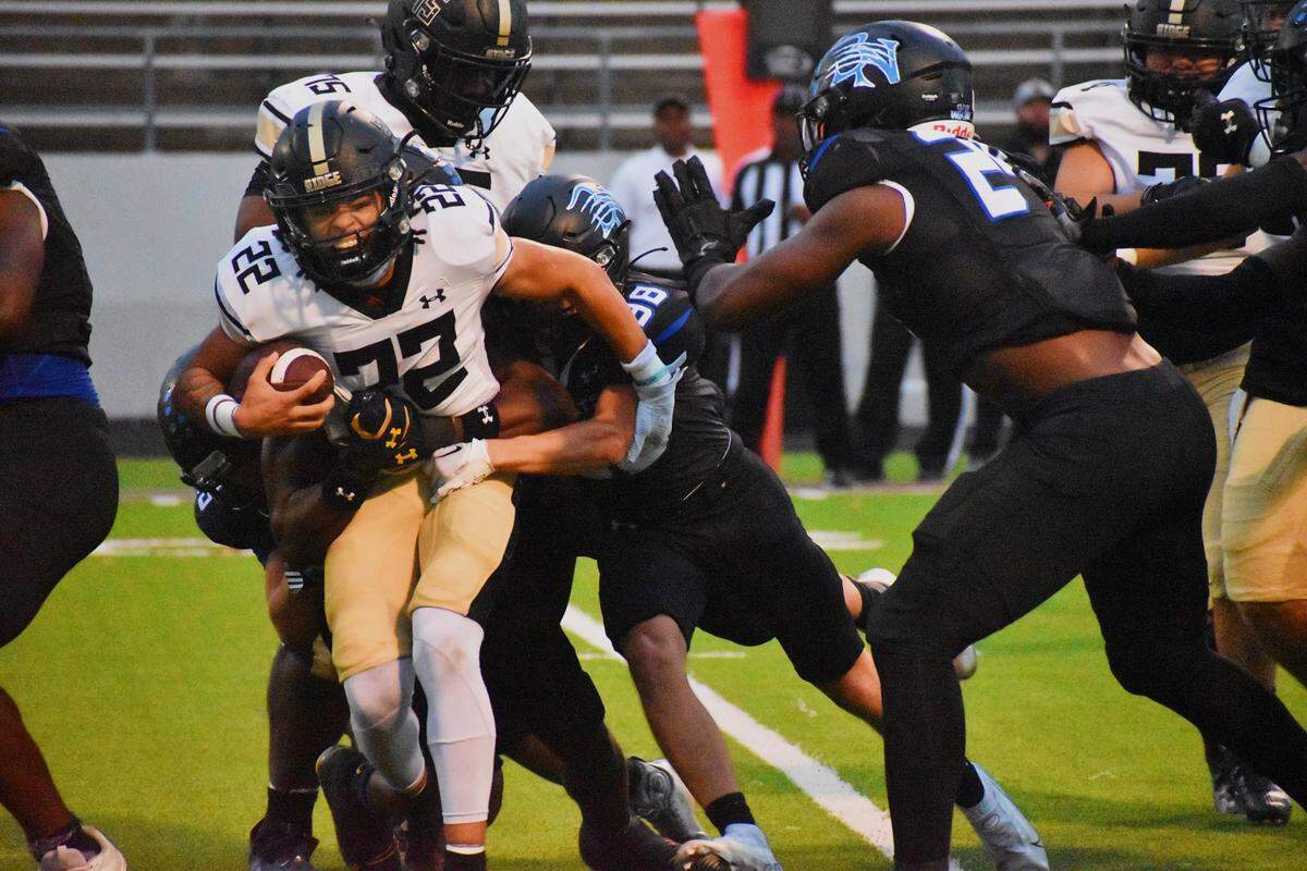 Fossil Ridge’s Cameron Moran (22) is tackled by a pair of Byron Nelson defenders during Thursday’s game at Northwest ISD Stadium in Justin.