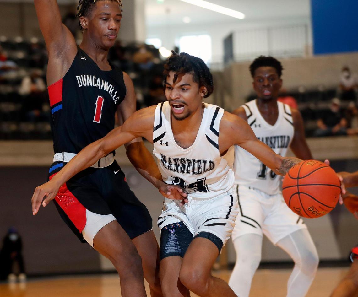 Mansfield guard Drew Crippen (24) drives into the paint defended by Duncanville forward Ron Holland (1) during the second half of a 6A Region 1 quarterfinal basketball game at Arlington ISD Athletics Complex in Arlington, Texas, Saturday, Feb. 27, 2021. Duncanville defeated Mansfield 73-53. (Special to the Star-Telegram Bob Booth)