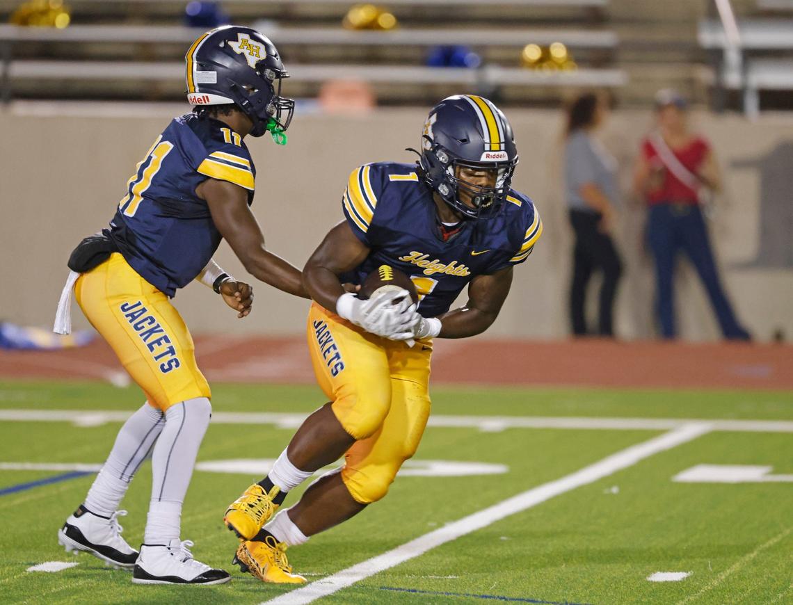 Arlington Heights quarterback Kaeden Grant (11) hands the ball to running back Carson James (1) during a District 4-5A D1 football game at Farrington Field in Fort Worth, Texas, Thursday, Oct. 10, 2024. (Special to the Star-Telegram / Bob Booth)