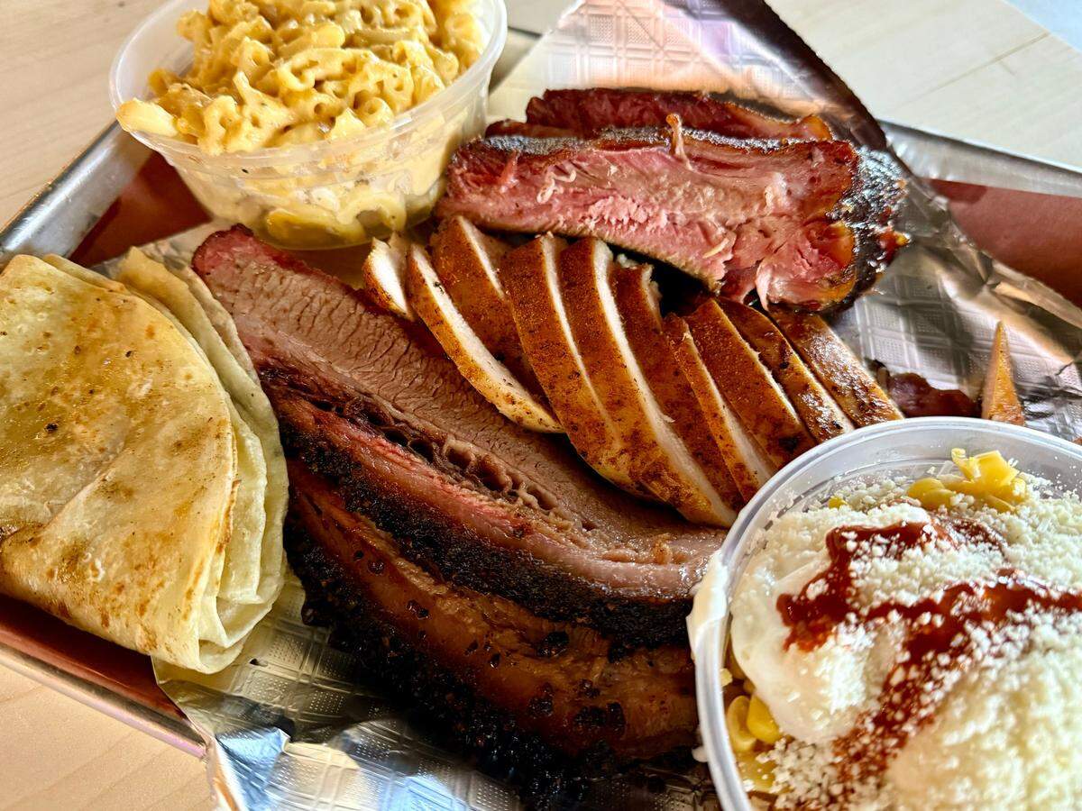 A combination plate with brisket, chicken and ribs at 225° BBQ, plus Mexican street corn and mac-and-cheese.
