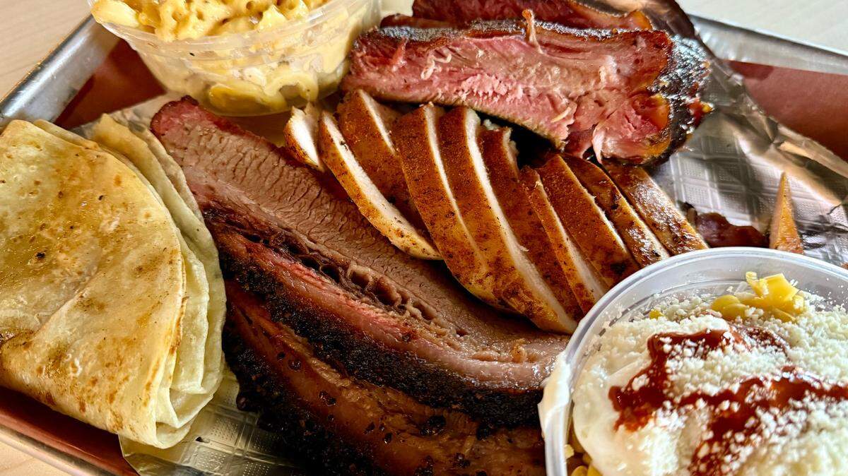 A combination plate with brisket, chicken and ribs at 225° BBQ, plus Mexican street corn and mac-and-cheese.